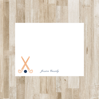 Personalized field hockey flat notecard with orange sticks, navy ball and navy name