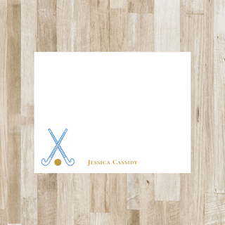 Personalized field hockey flat notecard with blue sticks, gold ball and gold name