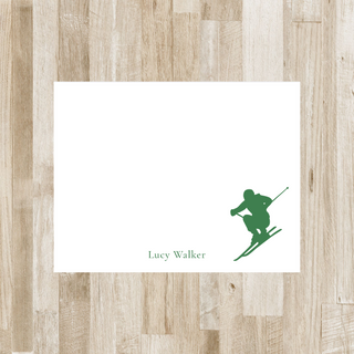 Personalized skier flat notecard with green skier and green name