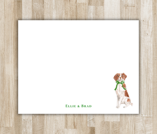 Personalized flat notecard with watercolor Brittany spaniel wearing a green bow and green name